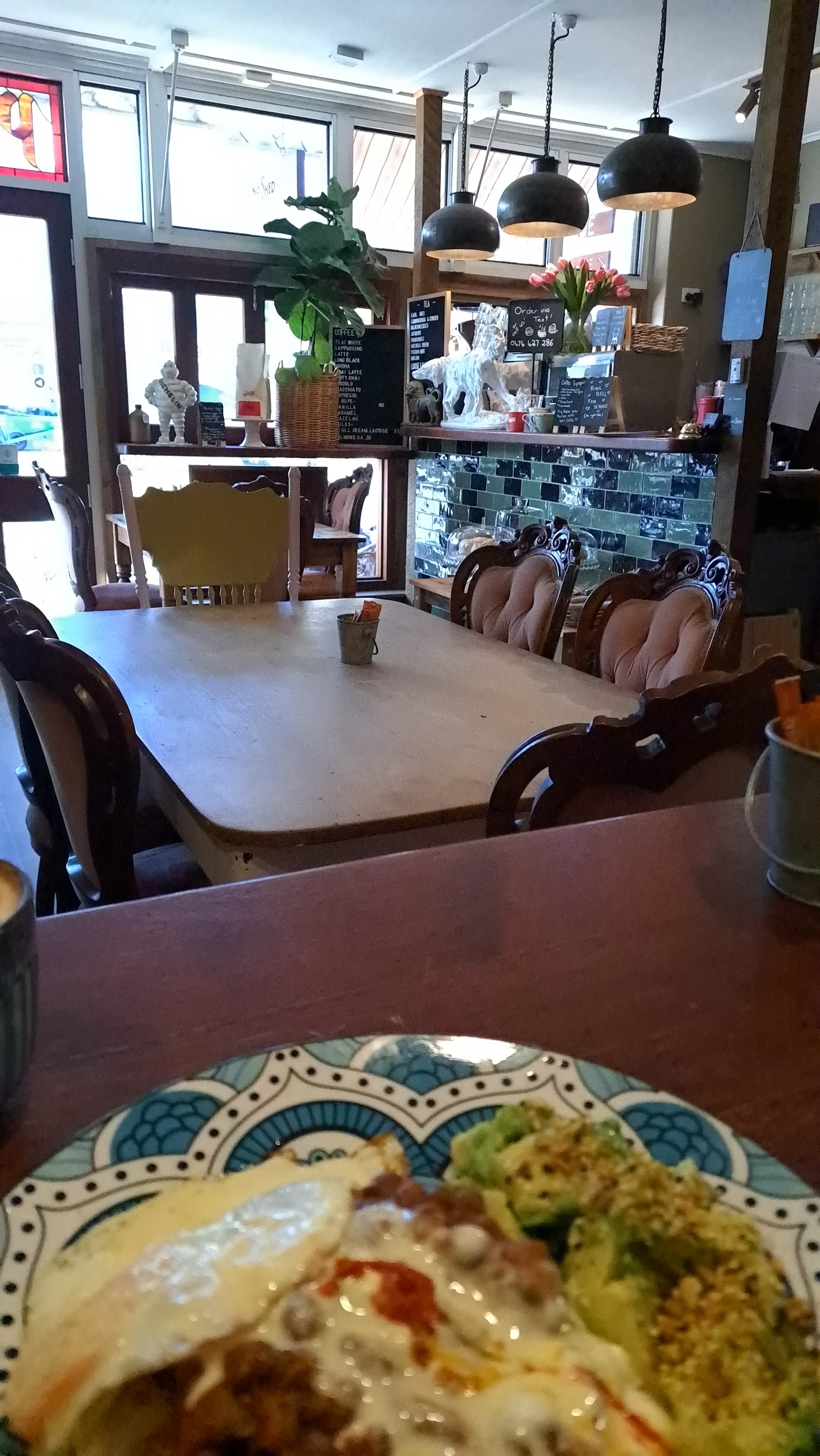 Inside the café: antique chairs, pendant lamps and the coffee counter