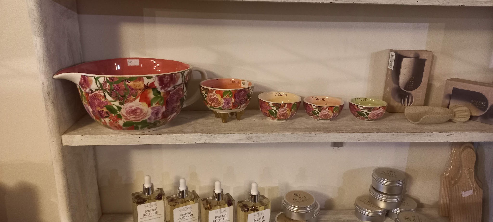 Floral ceramic mixing bowls and botanical body oil on the shop shelves